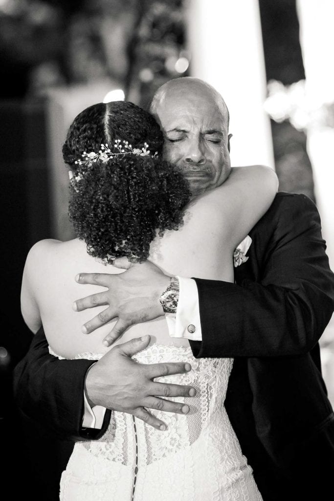 An emotional father-of-the-bride braces his daughter, the bride on her wedding day in New Orleans.