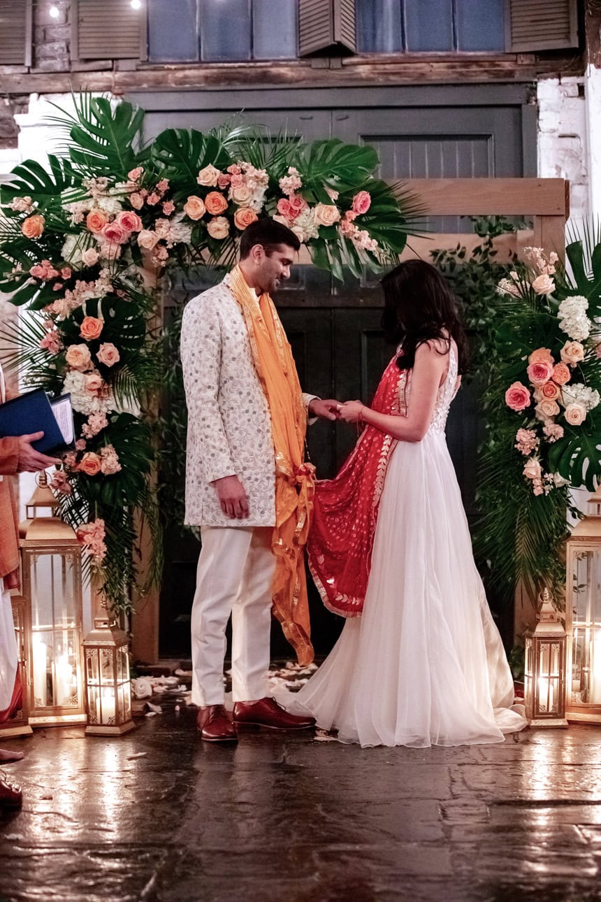 Bride and groom exchange rings by candlelight at an Indian wedding ceremony at Latrobe's in New Orleans.
