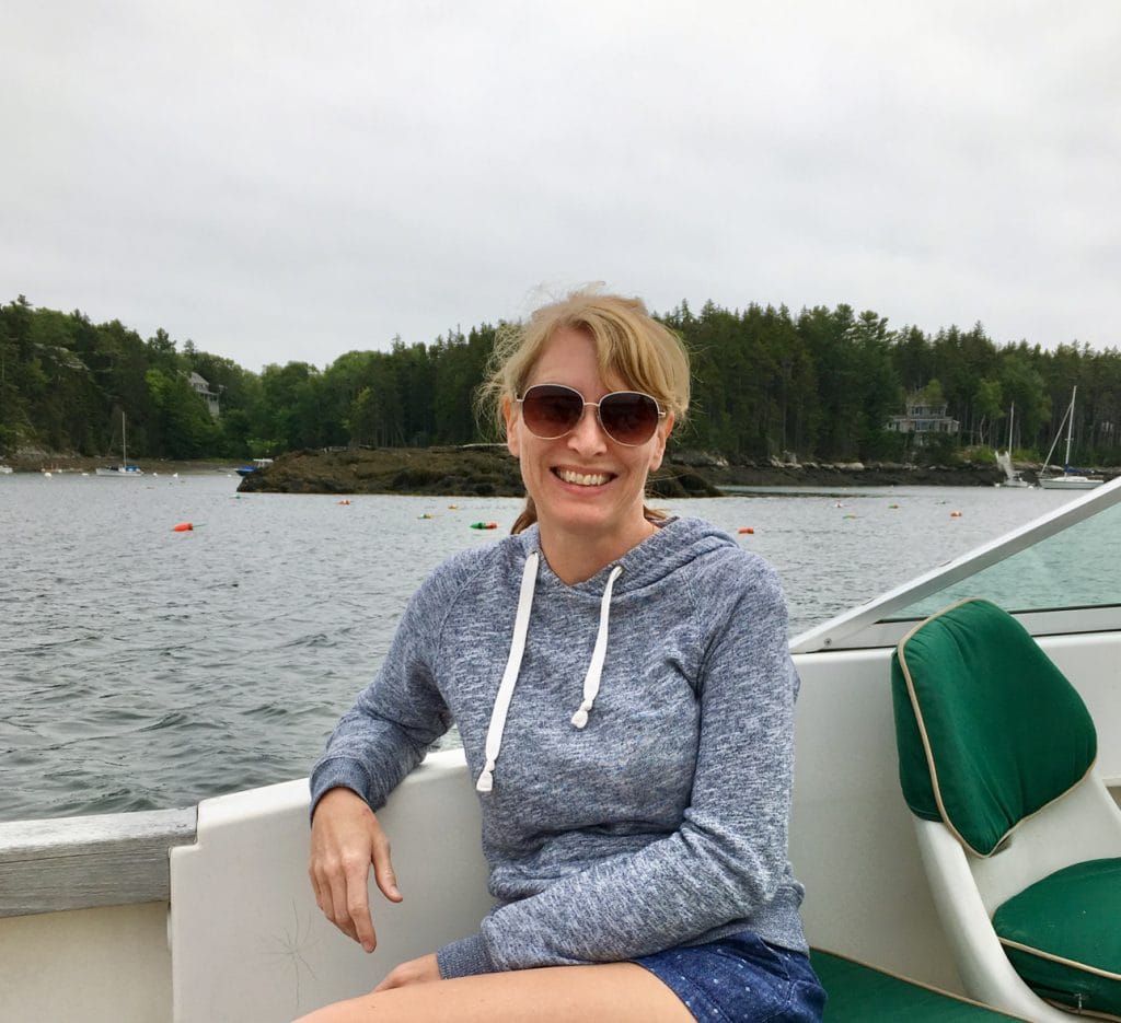 Liz King sitting on a boat in coastal Maine.