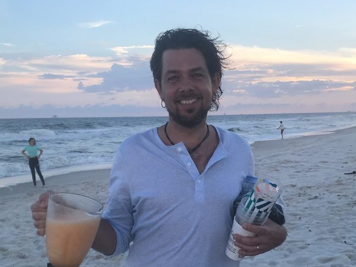 Matthew Foster on the beach with daiquiris at sunset.