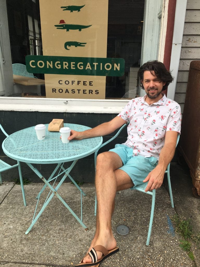 Matthew Foster enjoying a coffee outside at Congregation Coffee Shop in Algiers Point