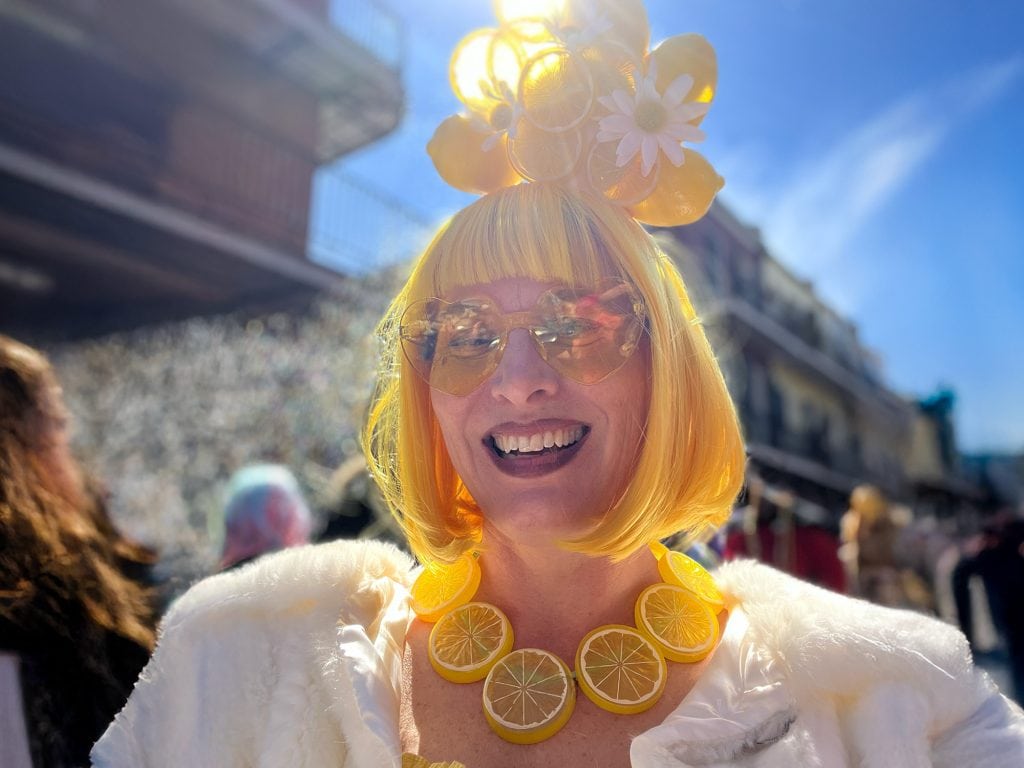 Liz King wearing a yellow wig with lemons on top on Mardi Gras Day in the French Quarter of New Orleans.
