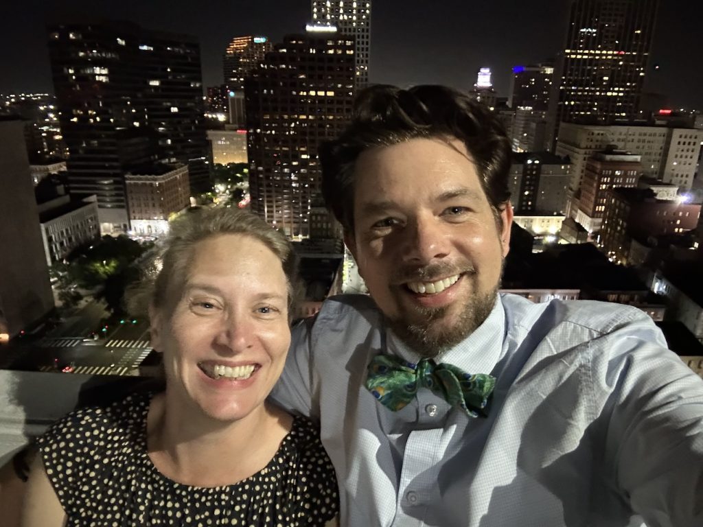 Wedding Photographers Matthew Foster and Liz King in front of New Orleans city view at night