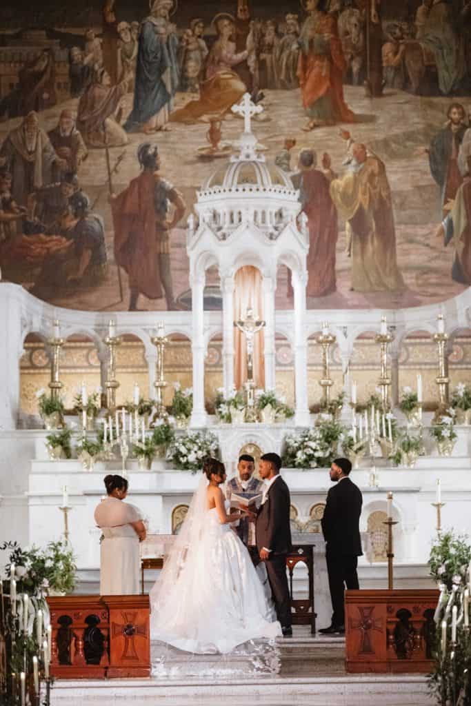 Elegant church wedding ceremony with bride and groom exchanging vows at altar.