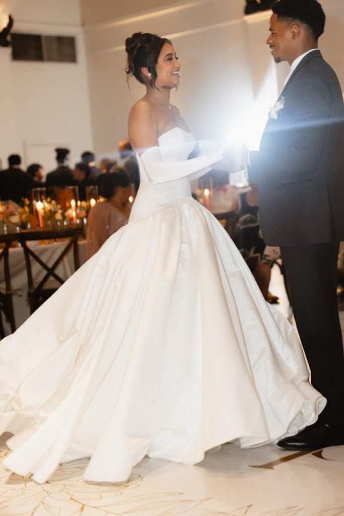 Couple dancing during wedding reception at stylish New Orleans venue, with warm candlelit ambiance.