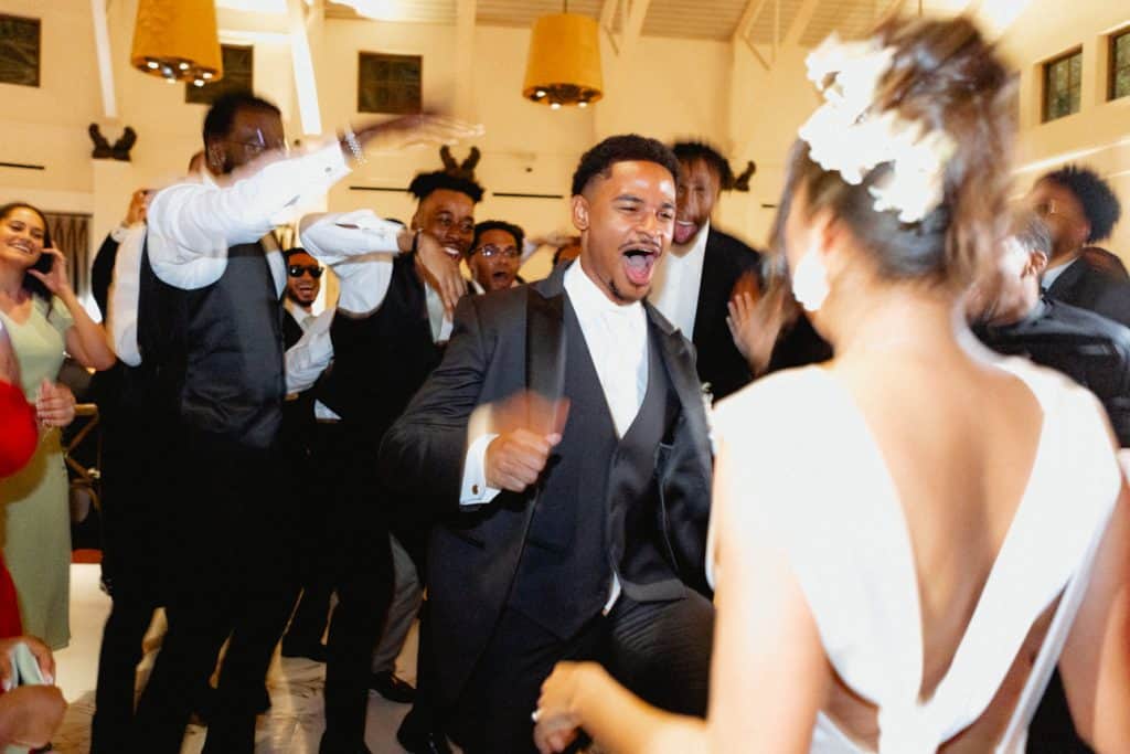 Vibrant wedding dance scene featuring joyful guests and lively atmosphere.