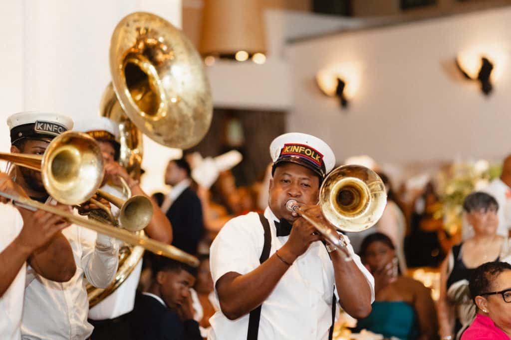 Celebrating with a lively jazz band, this wedding reception in New Orleans features brass musicians in uniform, creating a joyful atmosphere.
