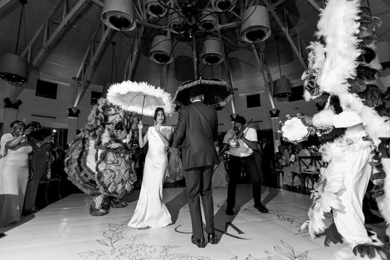 Vibrant New Orleans wedding scene with Mardi Gras Indians and a brass band.