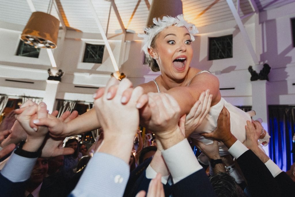 Bride crowd surfs at a wedding reception at the Audubon Tea Room in New Orleans.
