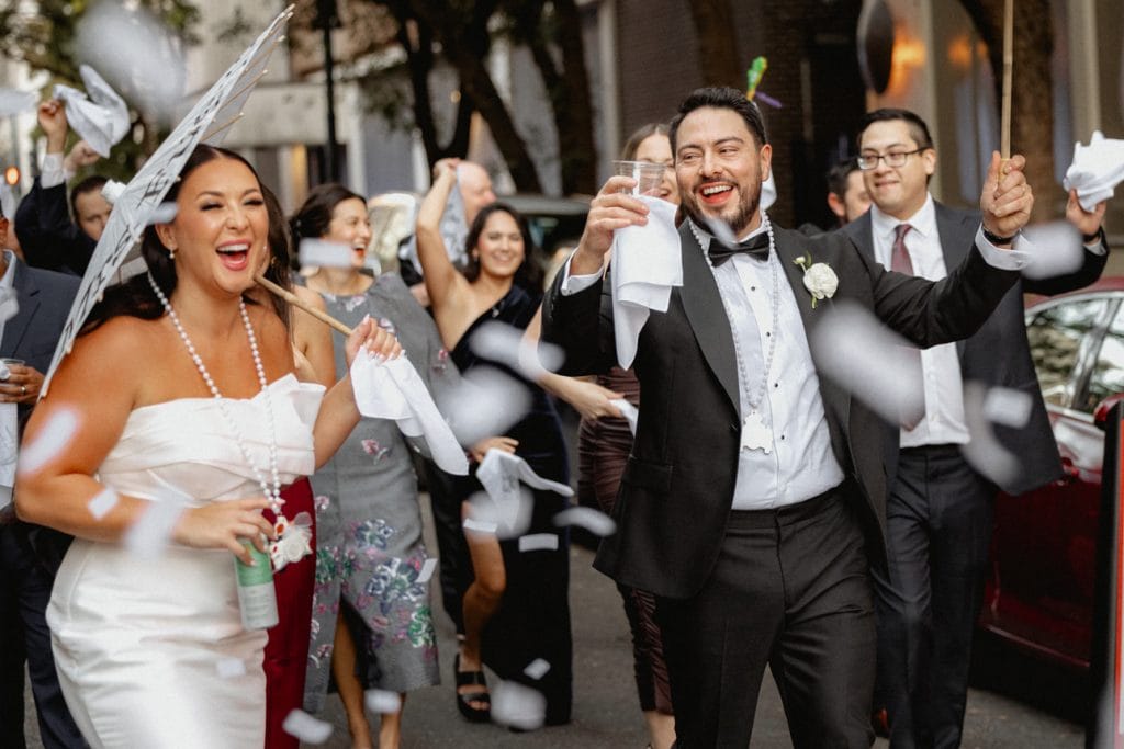 Celebration at the end of a wedding second line in New Orleans with joyful guests and confetti.