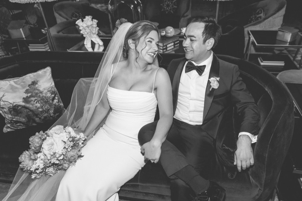 Elegant New Orleans wedding couple sitting on a vintage sofa.