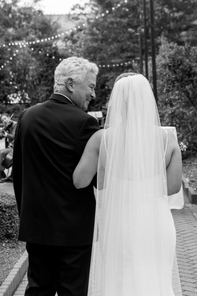 Bride and father share a special moment outdoors during a wedding celebration.