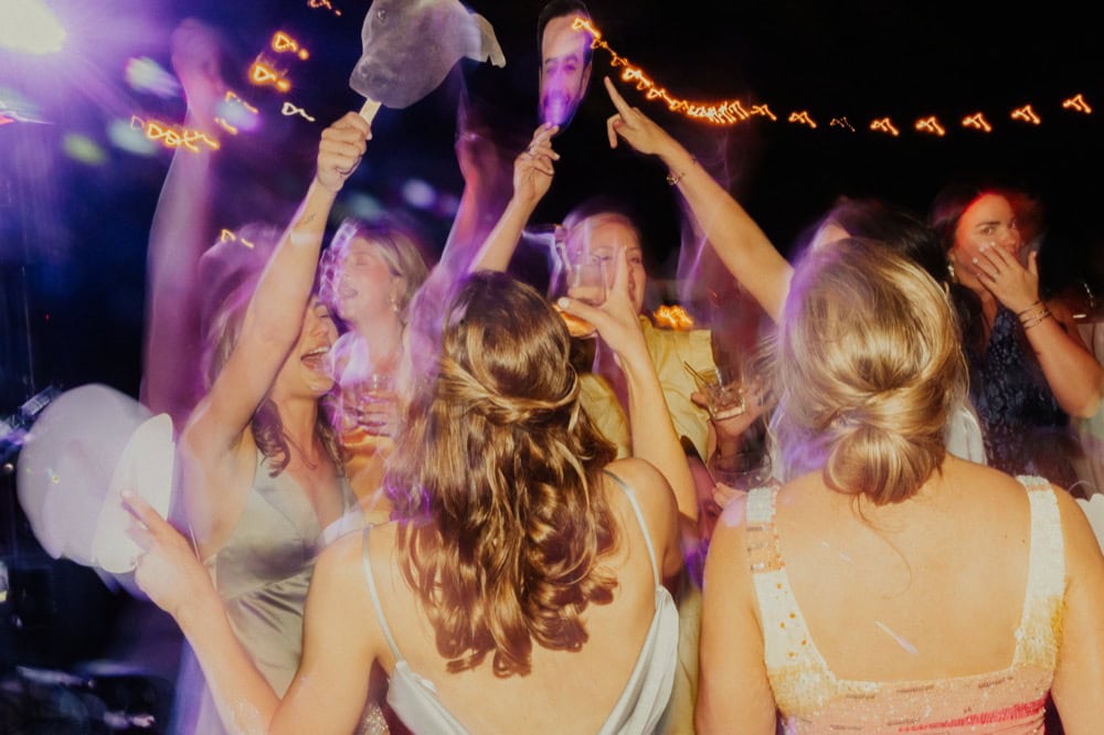 Elegant women dancing and celebrating at a lively New Orleans wedding reception.