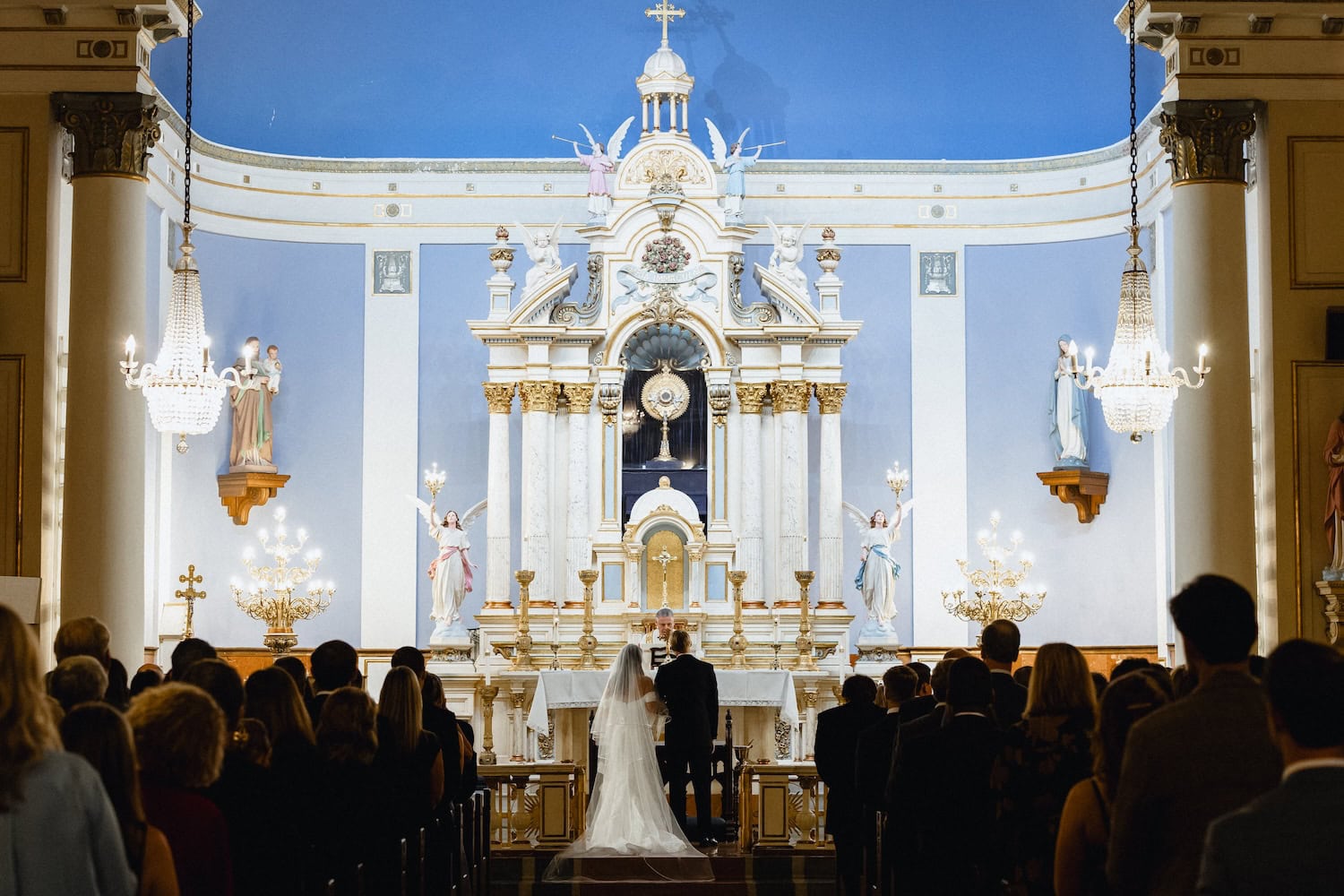 Bride and groom exchanging vows in the St. Mary's Catholic Church in New Orleans.