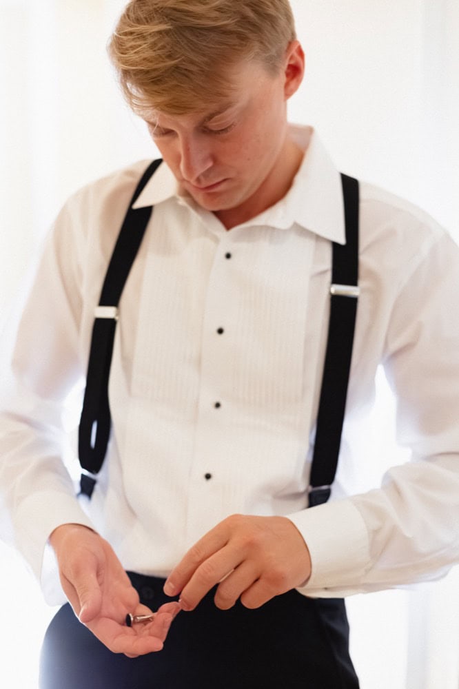 Groom adjusting his cufflinks before the wedding ceremony.