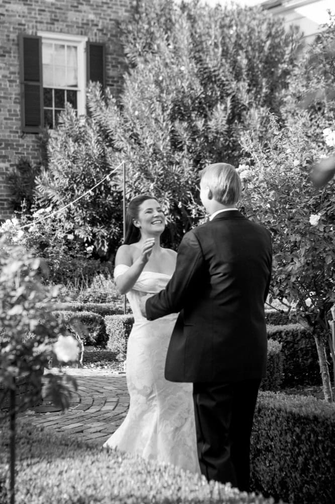 Beautiful black and white image of a bride and groom sharing a special moment in a garden setting.