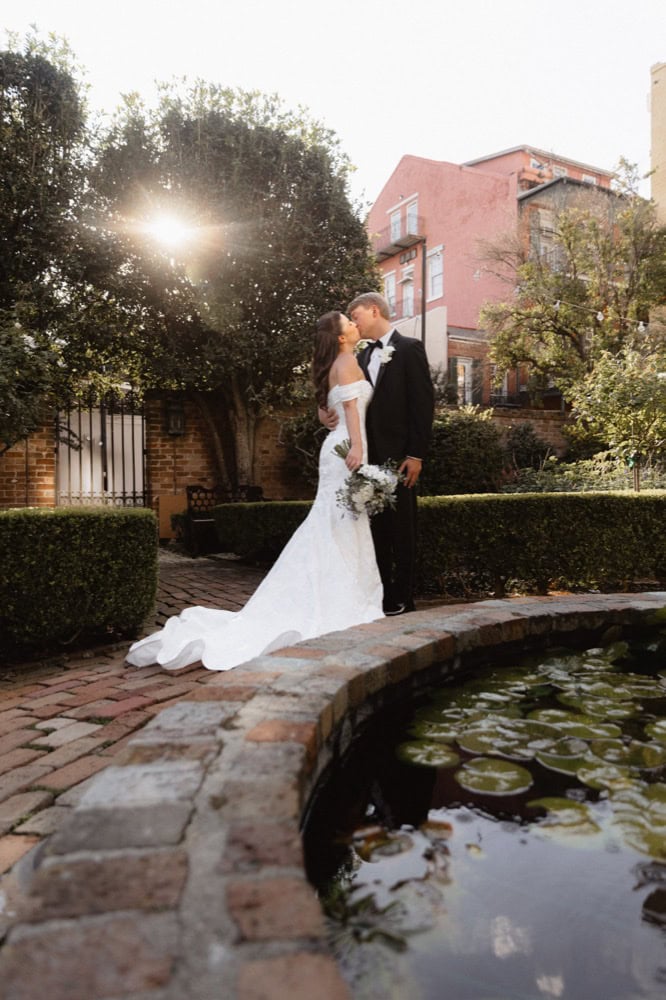 Wedding couple kissing in the gardens of the BK House at sunset, New Orleans.