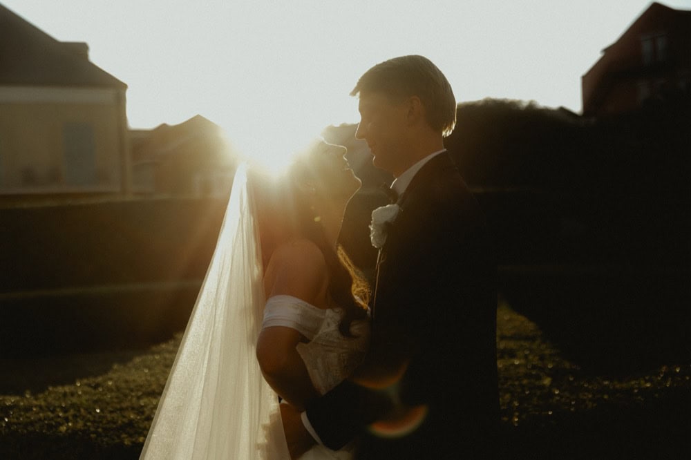 Wedding couple embracing at sunset in New Orleans, capturing a romantic moment in the gardens at the Old Ursuline Convent.