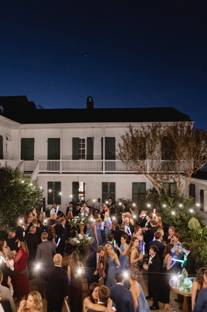 Nighttime wedding reception in New Orleans with guests dancing outdoors.