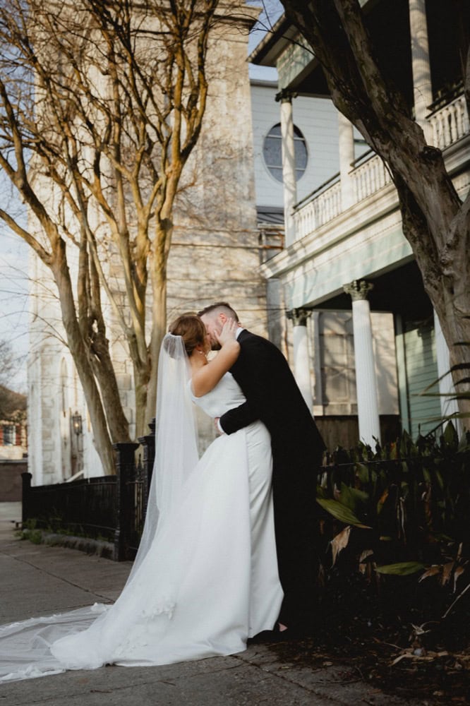 Wedding couple sharing a kiss outdoors in New Orleans.