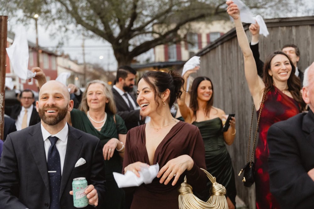 Wedding celebration in New Orleans with joyful guests dancing and smiling.