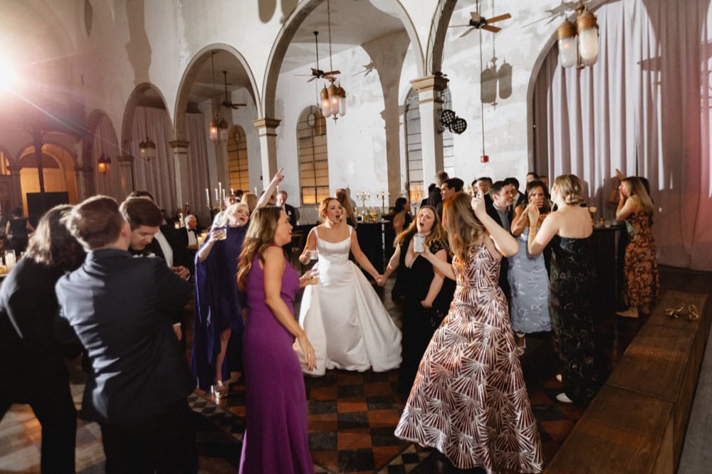 Wedding celebration at a historic venue with dancing and joyful guests.