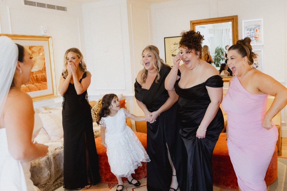 Bridesmaids react with joyful smiles as they see the bride for the first time on her wedding day in New Orleans.