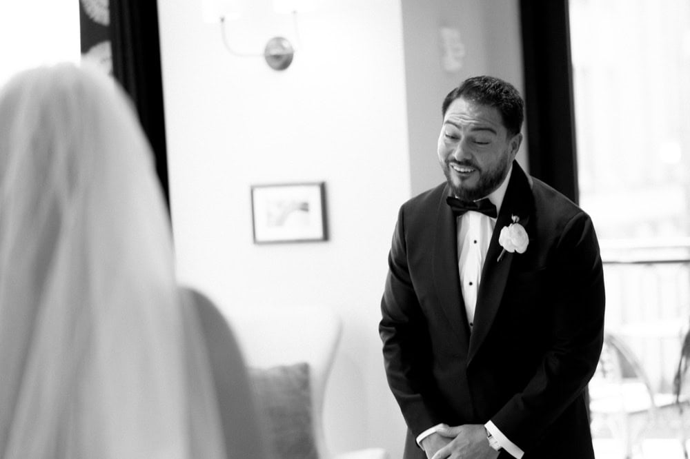 A groom smiles at his bride during their first look at the Virgin Hotel in New Orleans.