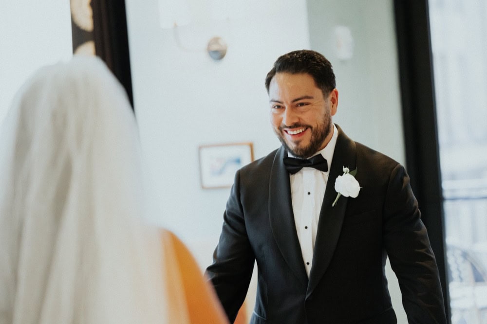 A groom smiles at his bride during their first look at the Virgin Hotel in New Orleans.