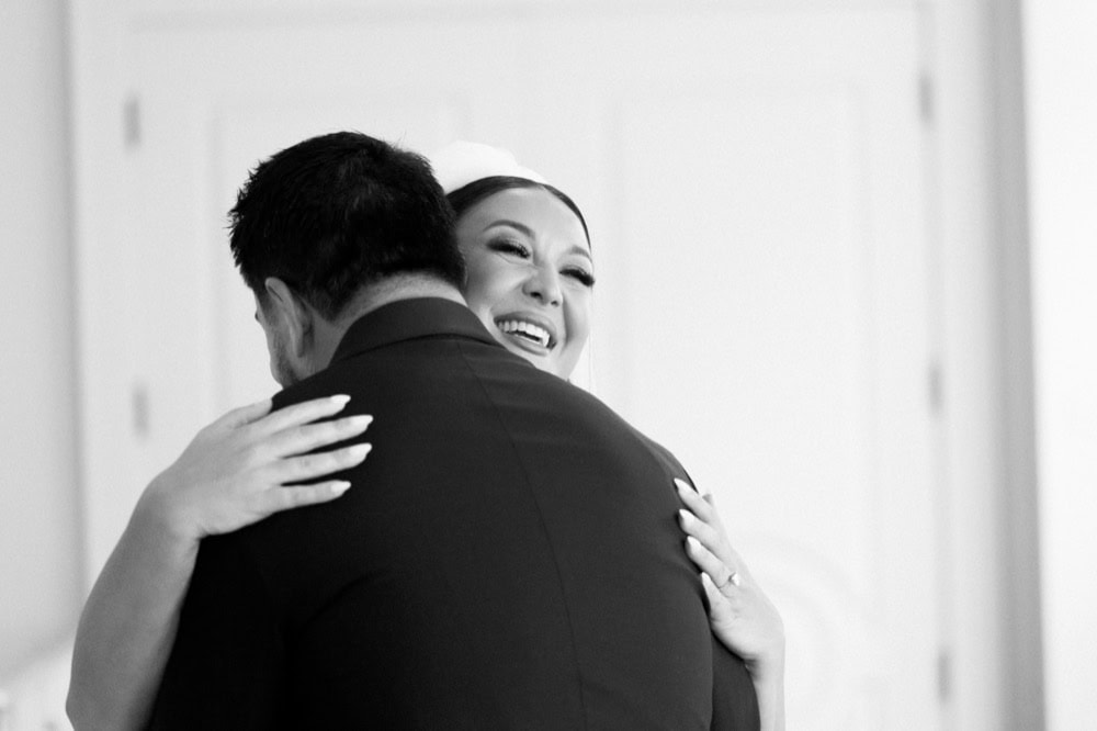 A bride smiles while embracing the groom during their first look at the Virgin Hotel in New Orleans.