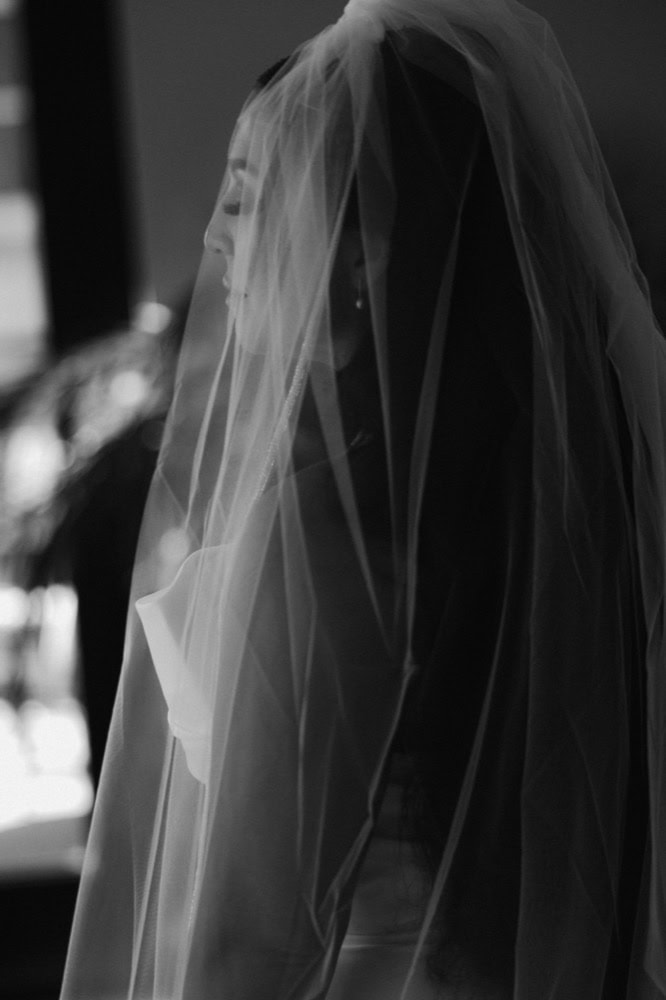 A bridal portrait of a bride with her veil covering her face.