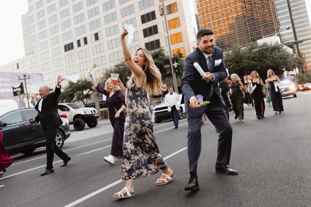 Wedding guests celebrating in New Orleans during a second line parade.