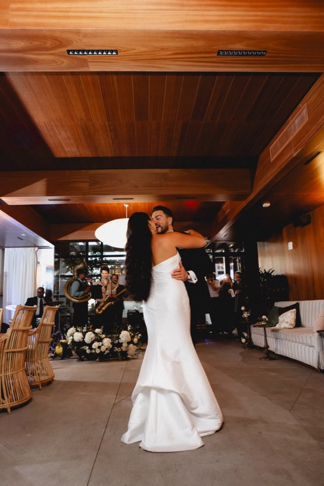 A bride and groom kiss during their first dance at their wedding reception at the Virgin Hotel in New Orleans.