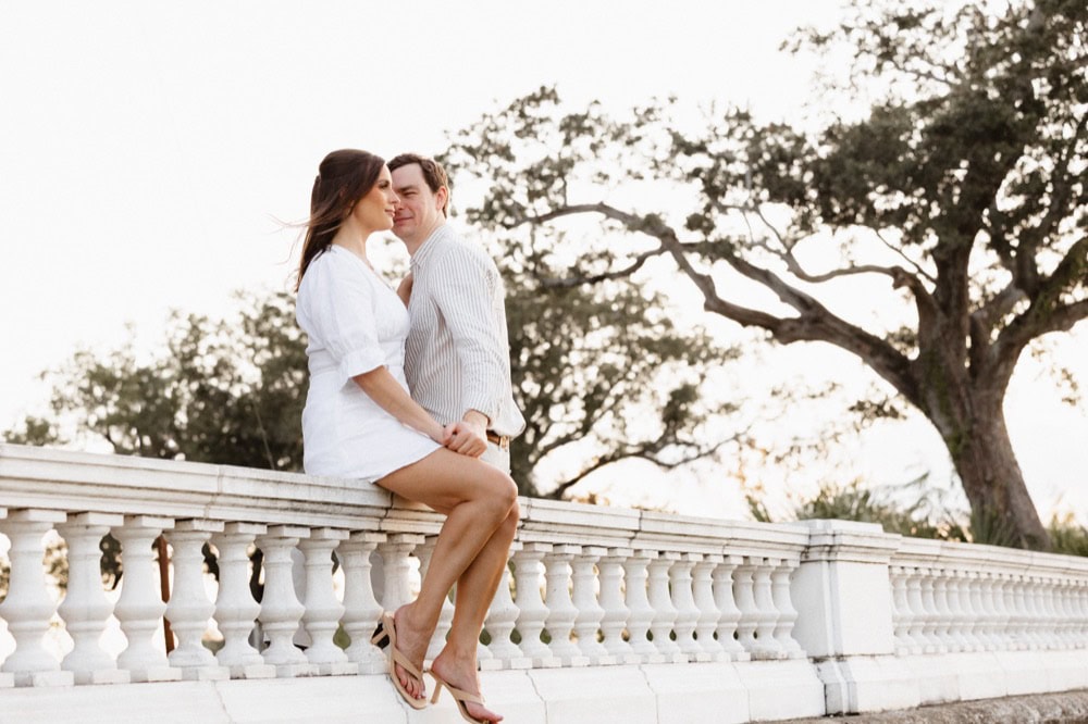 Romantic couple sitting on a white balustrade in New Orleans.