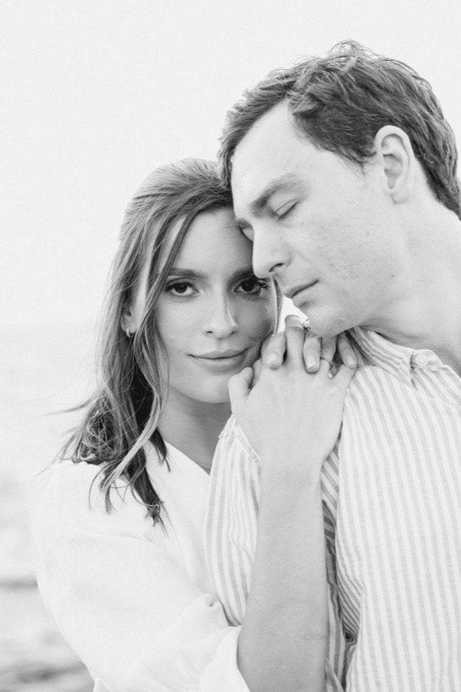 Black and white portrait of a bride and groom embracing outdoors.