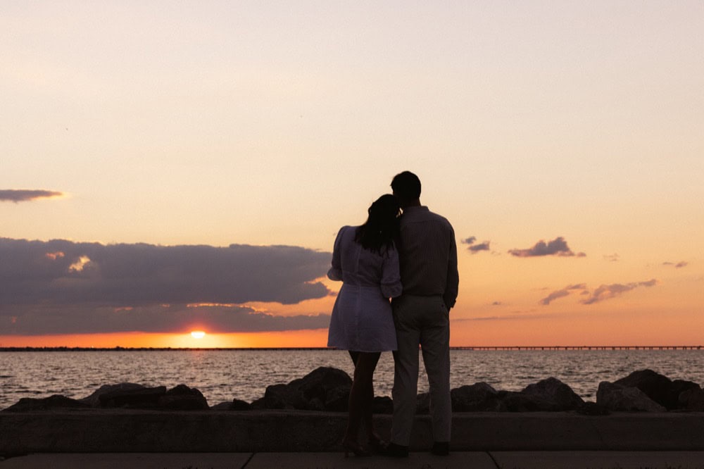 Couple watching sunset at the lakefront in New Orleans.