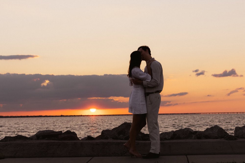 Couple kissing at sunset by the water in New Orleans.
