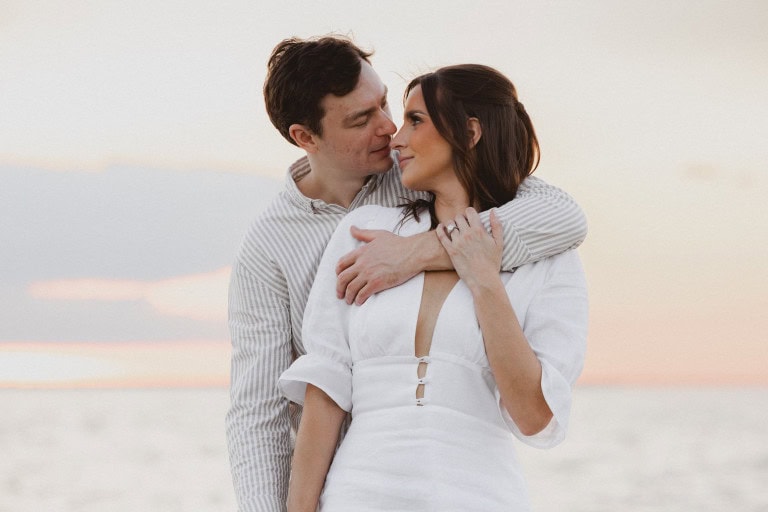 Romantic couple embracing on the lakefront at sunset in New Orleans.