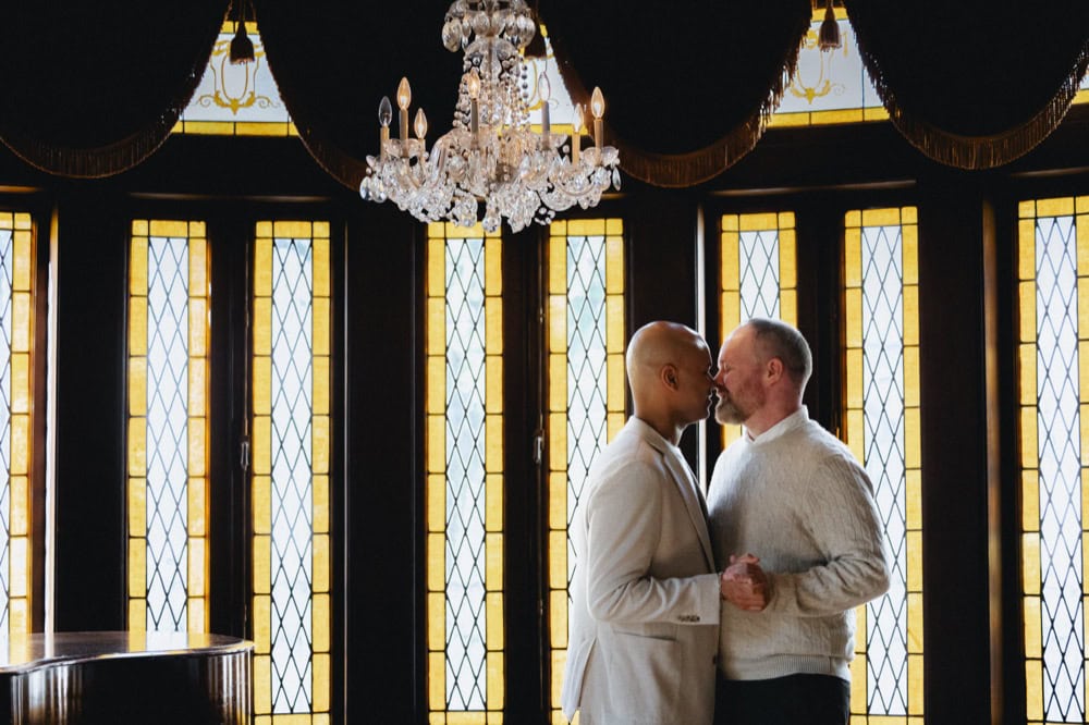 Intimate couple in front of stained glass windows at the Elms Mansion in New Orleans.