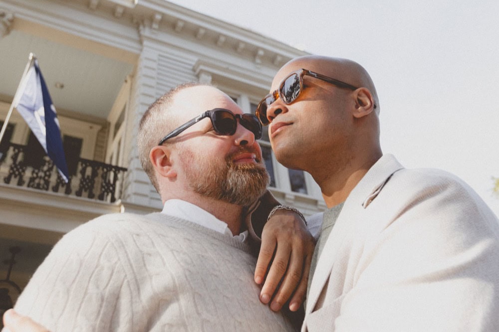 Two men in sunglasses close-up at their engagement photoshoot in New Orleans.