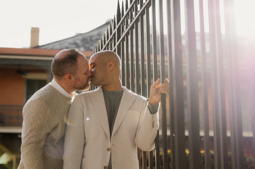 Couple sharing a kiss outdoors, romantic engagement moment in New Orleans.