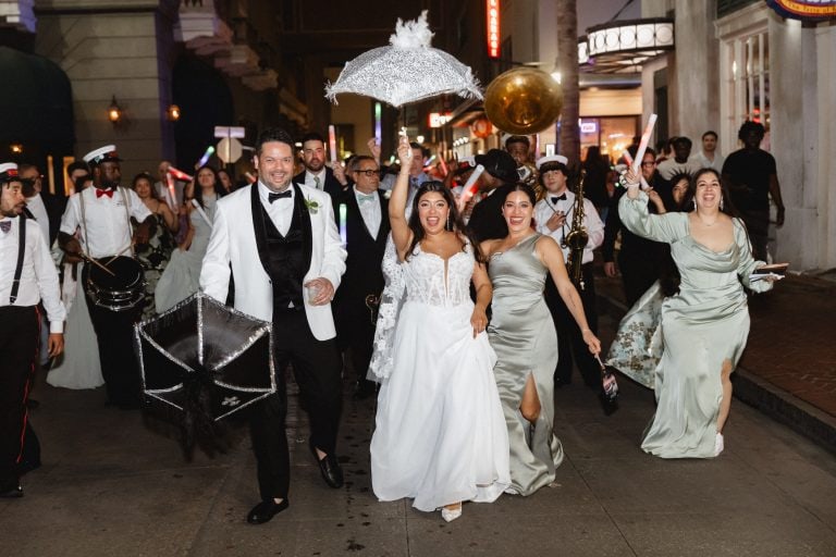 Wedding celebration in New Orleans with joyful couple and lively crowd.