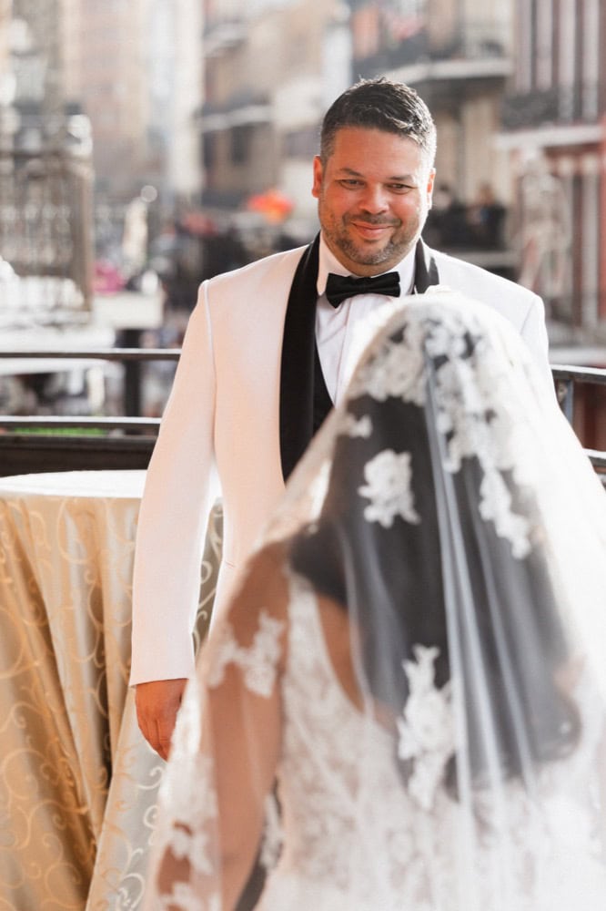 Wedding couple in New Orleans outdoor setting, groom smiling.