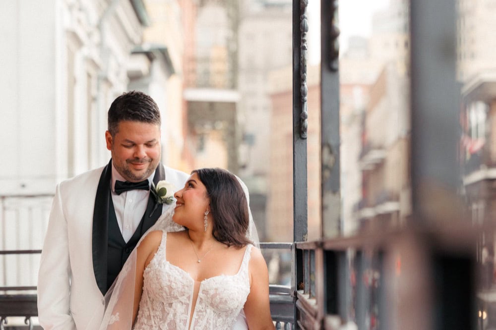 Wedding couple on balcony in New Orleans, romantic moment.