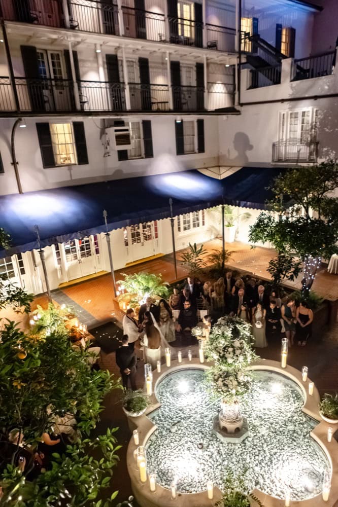 Wedding reception in a historic New Orleans courtyard with elegant decor and candlelit ambiance.
