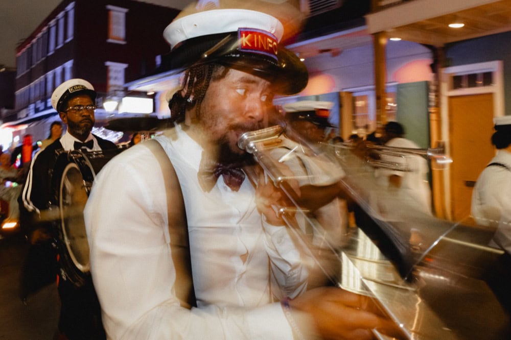 Jazz musician playing trumpet during a lively street performance in New Orleans.
