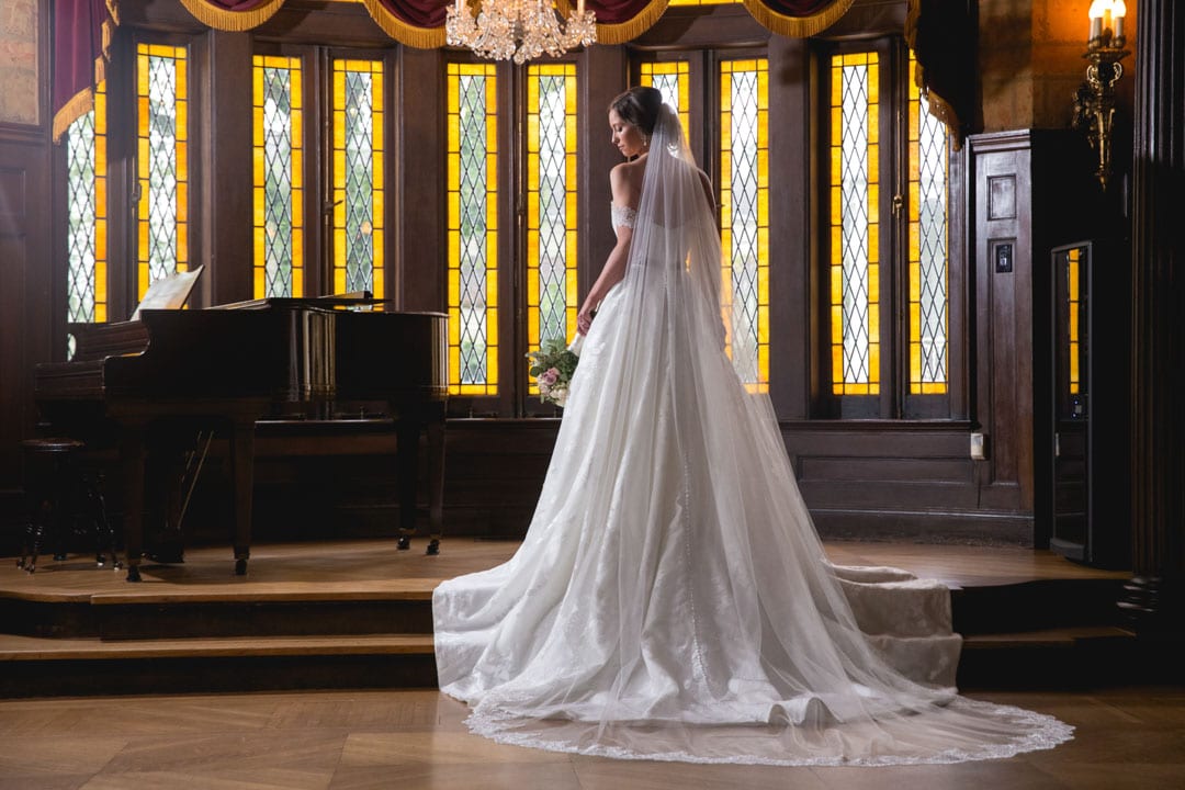 Bride in wedding gown with stained glass background in New Orleans venue.