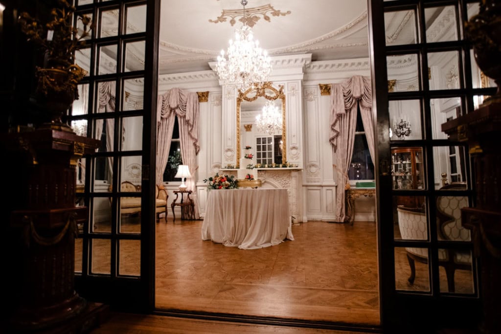 Luxurious wedding reception hall in New Orleans with chandelier and ornate decor.