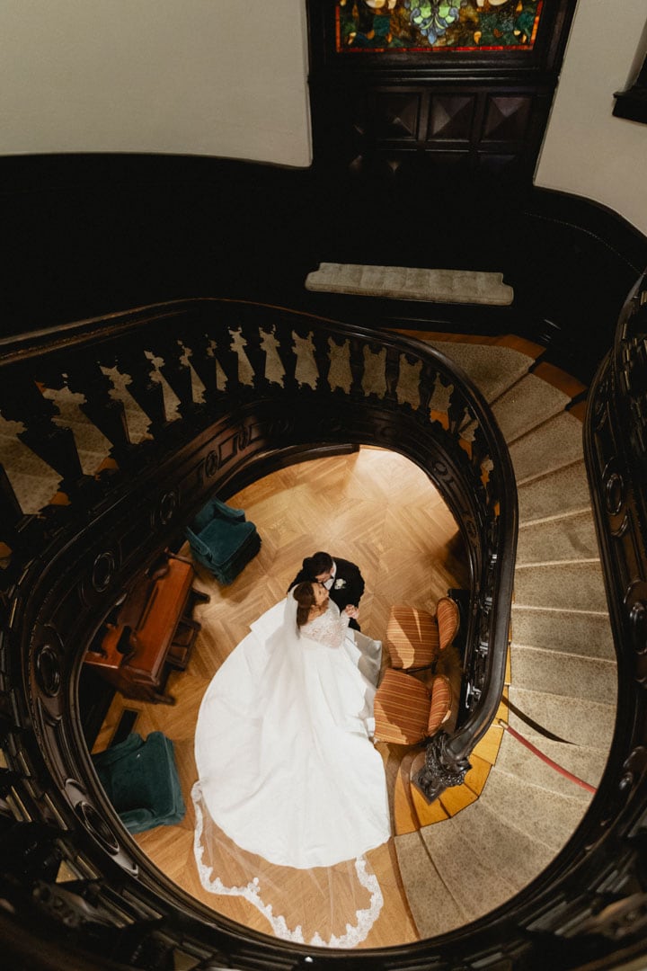 Bride and groom on spiral staircase during wedding in New Orleans.