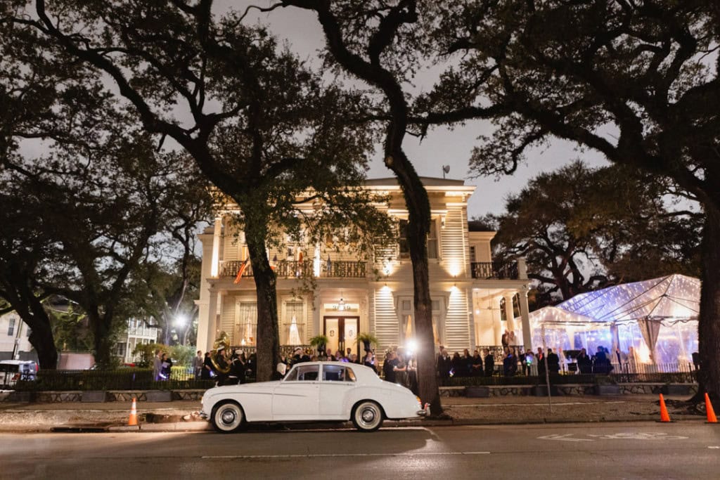 Elegant wedding venue in New Orleans with classic car and outdoor celebration.